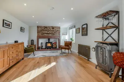 a living room with a fireplace and wooden floors at 3 Bed in Wigton oc-f33746 in Westward
