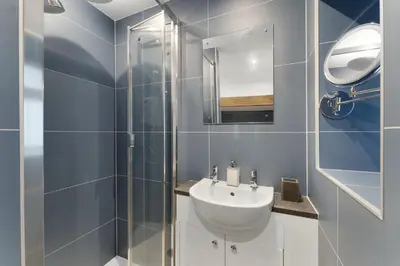 a bathroom with a sink and a glass shower at Walthwaite How Cottage in Chapel Stile