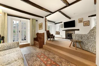 a living room with a couch and a fireplace at Walthwaite How Cottage in Chapel Stile