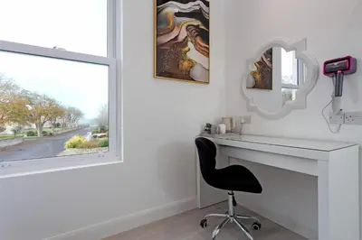 a desk and a chair in a room with a window at Savoy 5 in Ayr