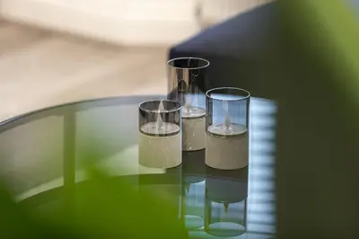 three glass vases sitting on a glass table at Stone Street Modern 3-Bed for Groups & Families in Broughton