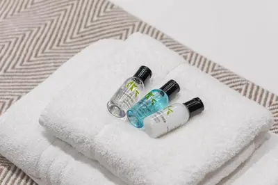 two bottles ofodorizers sitting on a towel on a bed at Stone Street Modern 3-Bed for Groups & Families in Broughton