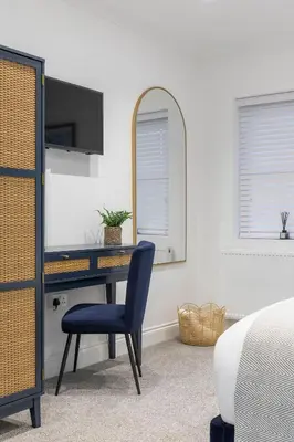 a bedroom with a desk with a chair and a mirror at Stone Street Modern 3-Bed for Groups & Families in Broughton