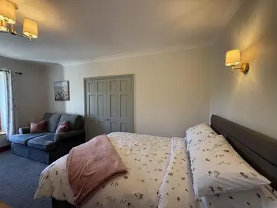 a bedroom with a bed and a couch at The Cottage in Keswick