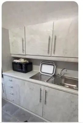 a kitchen with white cabinets and a sink and a window at Room with a view in Irvine
