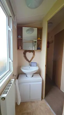 a bathroom with a white sink and a mirror at 17 Ruby Atlas Monreith in Monreith