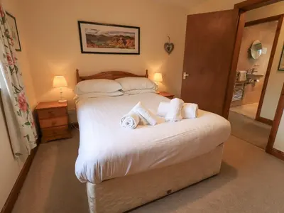 a bedroom with a large bed with towels on it at Thrang View in Ambleside