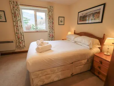 a bedroom with a bed with a teddy bear on it at Thrang View in Ambleside