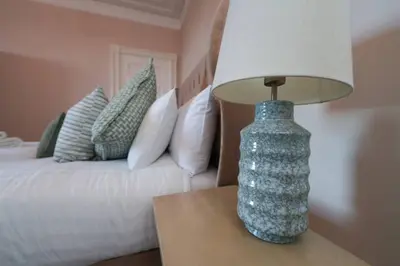 a lamp sitting on a table next to a bed at Mariners Haven in Troon in Troon