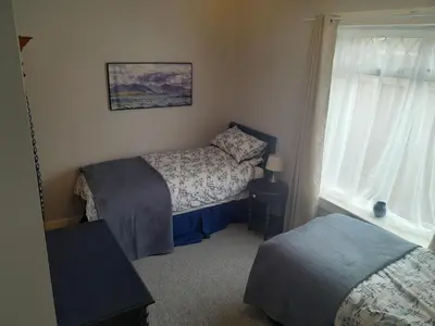 a small bedroom with two beds and a window at 2-Bedroom Flat South Ayrshire in Troon