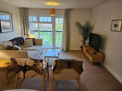 a living room with a couch and a tv at Carlisle Stunning 2 Bed Appt with Parking 5 mins J42 M6 in Carlisle