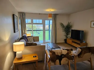 a living room with a couch and a tv at Carlisle Stunning 2 Bed Appt with Parking 5 mins J42 M6 in Carlisle