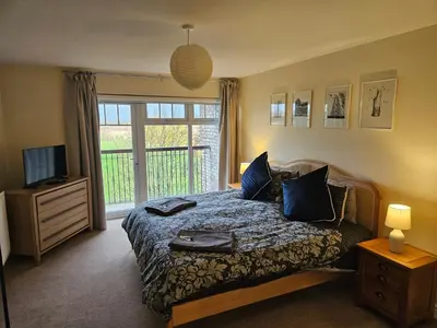 a bedroom with a bed and a tv and a window at Carlisle Stunning 2 Bed Appt with Parking 5 mins J42 M6 in Carlisle
