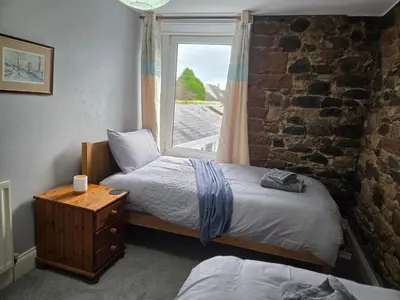 a bedroom with two beds and a window at Feather Bed Cottage - Dog Friendly Lakeland Retreat with Log Burner & Garden