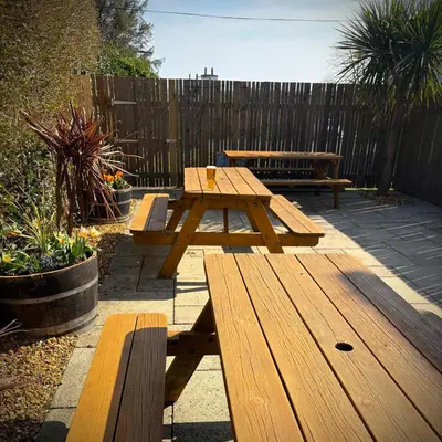 a wooden picnic table and benches in a backyard at The Wigtown Ploughman in Wigtown