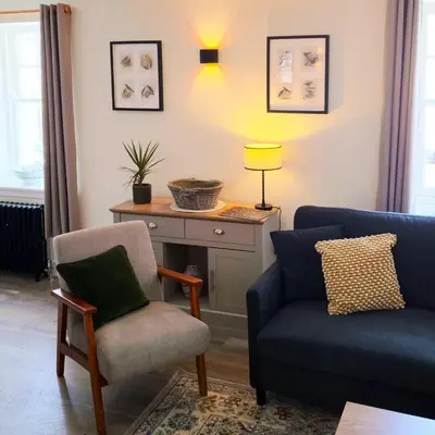 a living room with a couch and a chair at The Wigtown Ploughman in Wigtown