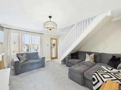 a living room with a couch and a staircase at The Haven Holiday Home in Woodend