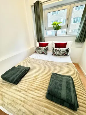 a large bed in a room with a window at Entire 4 bedrooms Apartment Sleep 8 Central London ZONE1 in Moffat