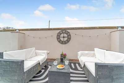 a patio with two wicker chairs and a table at 5 Bed in Galston oc-s33451 in Galston