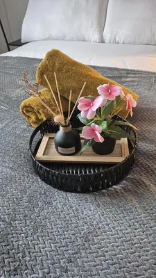 a tray with two vases with flowers on a bed at Cockermouth Cottage - Lakes - Parking in Cockermouth