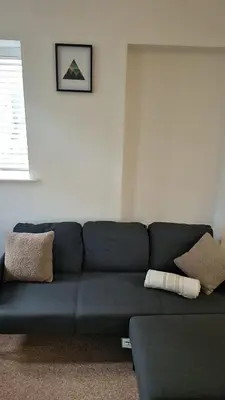 a black couch in a living room with pillows at Cockermouth Cottage - Lakes - Parking in Cockermouth