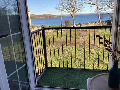a screened in porch with a view of the water at Seascape - a Luxury Retreat on the Sea in Moffat