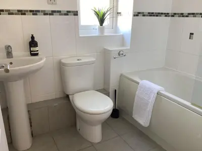 a white bathroom with a toilet and a sink at Seascape - a Luxury Retreat on the Sea in Moffat