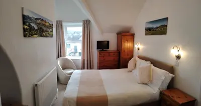 a hotel room with a bed and a chair at Dunsford Guest House in Keswick