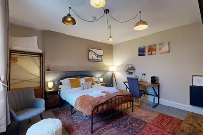 a bedroom with a bed and a chair and a desk at The Briery in Workington