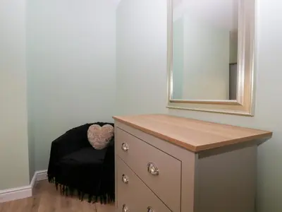 a bathroom with a dresser and a mirror at Mables in Wigton
