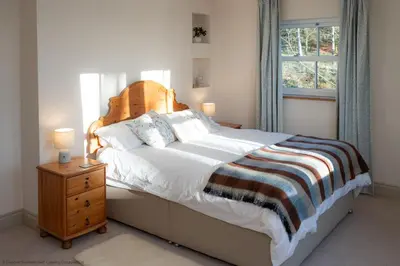 a bedroom with a large bed and a window at Craignair in Castle Douglas