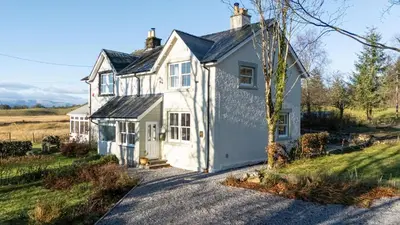 a white house on a gravel road at Craignair in Castle Douglas