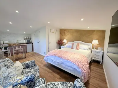 a bedroom with a large bed and a kitchen at Wild Meadow Cottage - Countryside Views and King Bed in Maybole