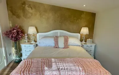 a bedroom with a large bed with two night stands at Wild Meadow Cottage - Countryside Views and King Bed in Maybole