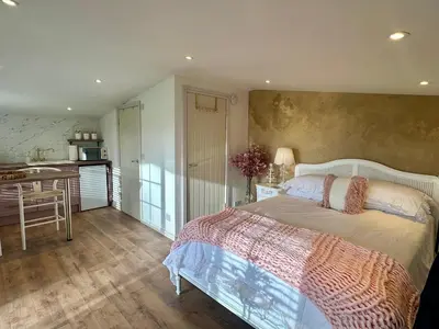 a bedroom with a bed and a kitchen at Wild Meadow Cottage - Countryside Views and King Bed in Maybole