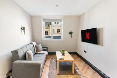 a living room with a couch and a tv at Newly Renovated 1BR Steps from Hove Beach in Moffat