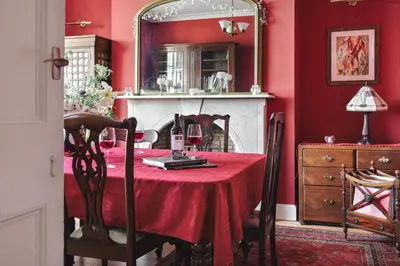 a red dining room with a table and a mirror at Seaside ParkView Near Lake District and Marina - Pass the Keys in Whitehaven