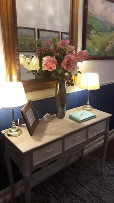 a table with two lamps and a vase with flowers on it at Bed And Blueberry Two Bed Suite for 2,3, or 4 people in Douglas