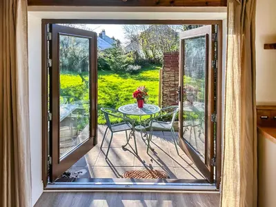 a patio with a table and a view of a yard at Lime Tree Barn in Tallentire