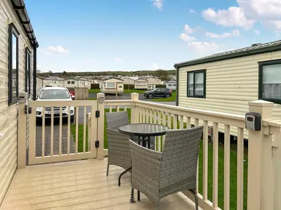 a patio with a table and chairs on a deck at Ali B's Craig Tara in Ayr