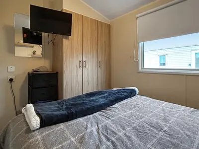 a bedroom with a bed with a large blue pillow on it at Ali B's Craig Tara in Ayr