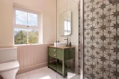 a bathroom with a sink and a shower at Orroland Holiday Cottages in Dundrennan