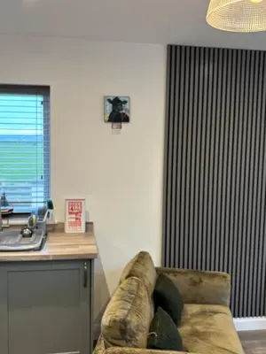 a couch sitting in a living room next to a kitchen at Cross Beck Cottage in Allonby