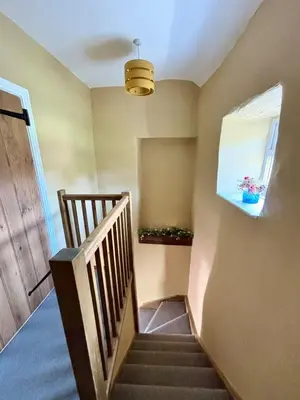 a staircase in a house with a window at Maggies Cottage in Little Broughton