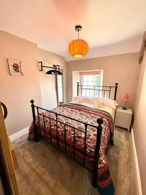 a bedroom with a bed in the corner of a room at Maggies Cottage in Little Broughton