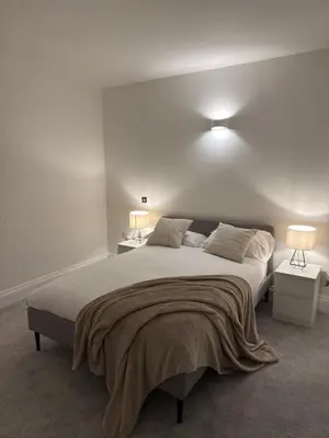 a bedroom with a large bed with two lamps on it at Cosy Greenwich Flat Near -Cutty Sark, River & Park in Moffat