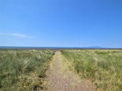 a dirt road in the middle of a field at 3 Bed in Maryport oc-sz102 in Allonby