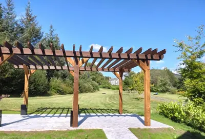 a wooden pergola in a park at Gate Lodge in Castle Douglas
