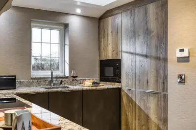 a kitchen with a sink and a refrigerator at Courtyard Cottage in Castle Douglas