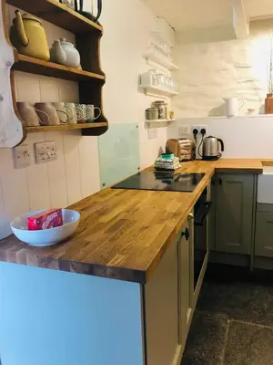 a kitchen with a wooden counter top in a room at Romantic Cottage, Port Isaac in Moffat